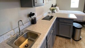 A compact kitchen with a stainless steel sink, a built-in stove, and a small trash can. - ⭐️Private stand-alone studio Central⭐️ (El Paso)