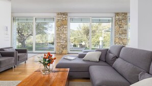 Ein modernes Wohnzimmer mit einem grauen Sofa, einem Holztisch und einem Blumenstrauß.