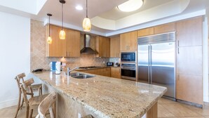 A modern kitchen with granite countertops, stainless steel appliances, and wooden cabinets.