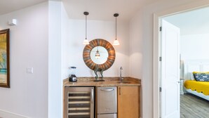 A compact kitchen with a refrigerator, a sink, and a blender on the countertop.
