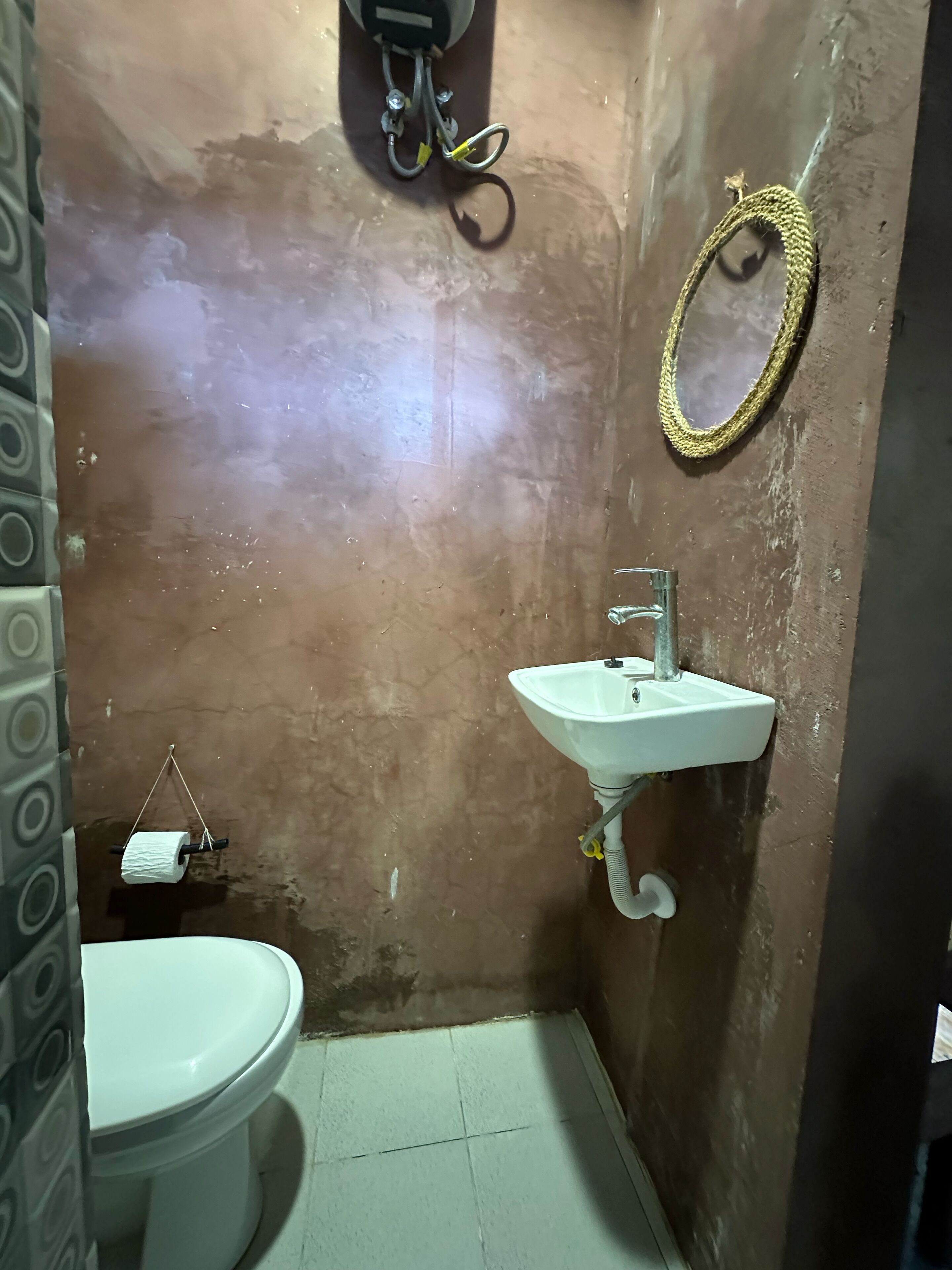 Une petite salle de bain avec des toilettes, un lavabo et un miroir.