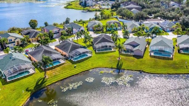 Oversigtsbillede fra luften af et boligområde med huse, en sø og en flod.