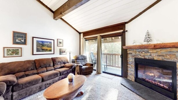 A cozy living room with a fireplace, a sofa, a coffee table, and framed pictures on the wall. - The Summit 66 Walk to Eagle Lodge Chair 15 (Mammoth Lakes)