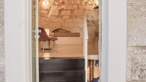 An arched doorway leading to a staircase with a stone wall and a number 11 sign.