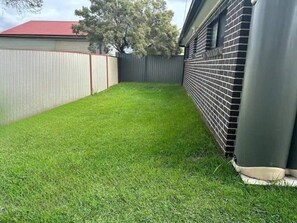 Enjoy a serene outdoor space surrounded by lush greenery and a fence.
