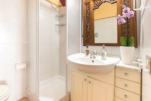 A bathroom with a white sink, a mirror, a toilet, and a shower. - LUNA BAY HOME RETREAT with a view of Porto Luna Bay, 2 km from Villasimius (VILLASIMIUS)