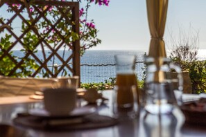 Outdoor dining - LUNA BAY HOME RETREAT with a view of Porto Luna Bay, 2 km from Villasimius (VILLASIMIUS)