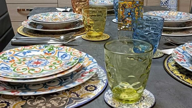 Una cocina con baldosas estampadas, un microondas y diverso menaje de cocina.