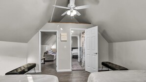 A bedroom with two beds, a ceiling fan, and a hallway leading to another room. - The Davey Retreat (Buffalo)