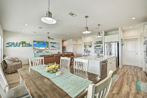 A spacious kitchen with a dining area, white cabinetry, and a central island.