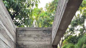 Eine Duschkabine aus Beton mit Brausekopf und Handbrause.