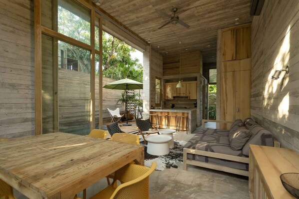Un espace de vie moderne, à aire ouverte, avec un intérieur en bois, un coin repas et une cuisine.