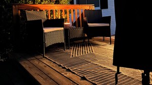 An outdoor deck with wooden flooring, a dining table, and two chairs. - Fantastic Master’s Rental- 1 mile away! (Augusta)