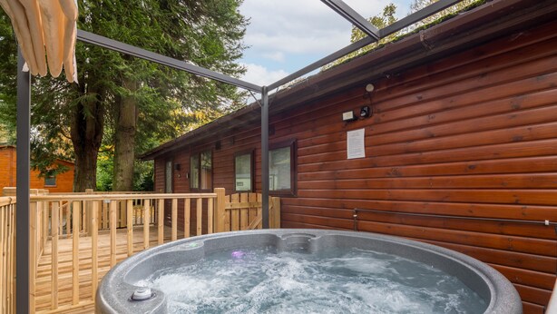 A hot tub in a wooden cabin with a wooden deck and a pergola. - Firgarth Lodge  - sleeps 6 guests  in 3 bedrooms (Windermere)