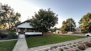 A residential house with a front yard, a driveway, and a street view.