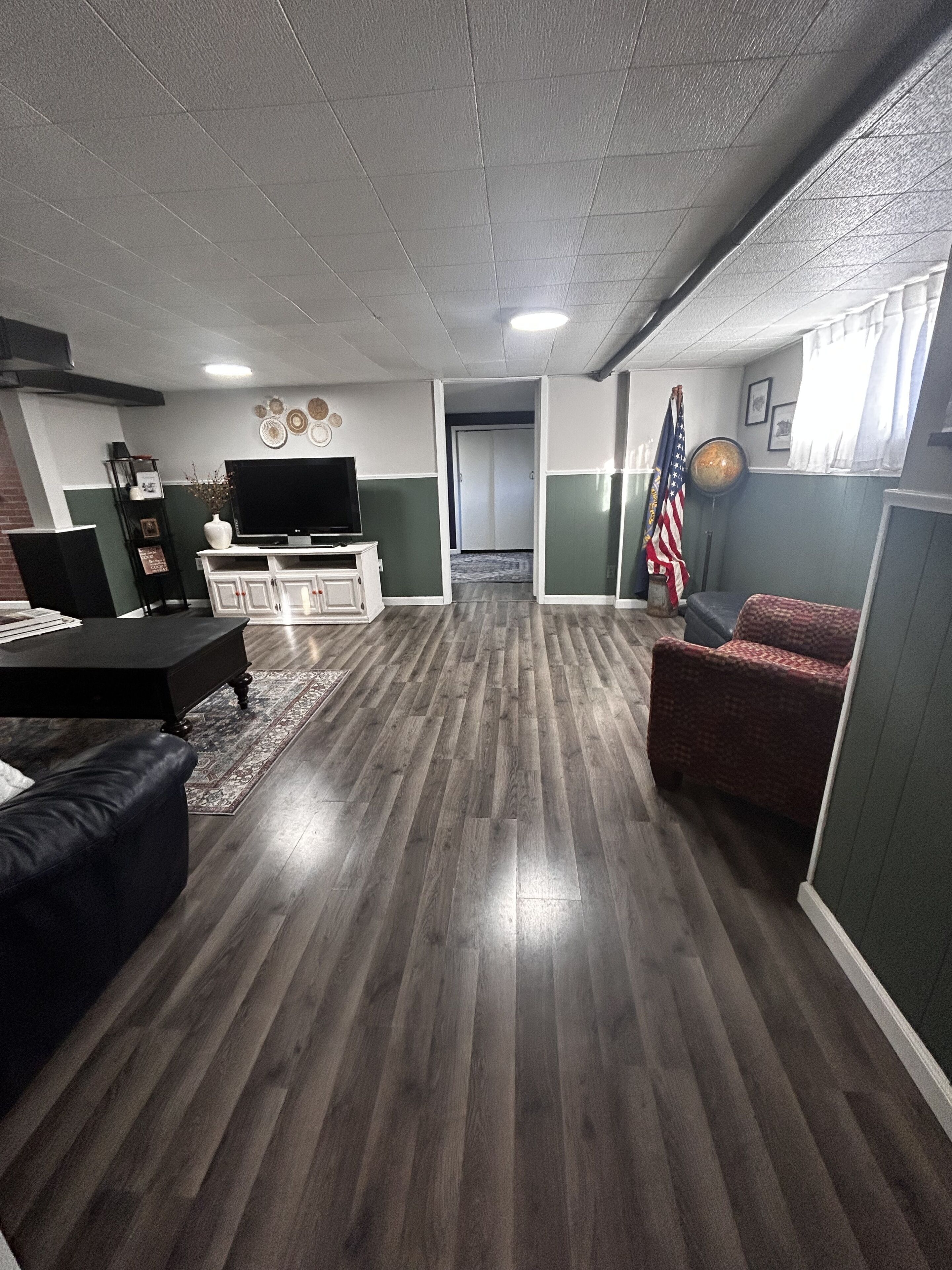 Una sala de estar con un televisor de pantalla plana, una mesa de centro, un sofá y un tapete estampado.
