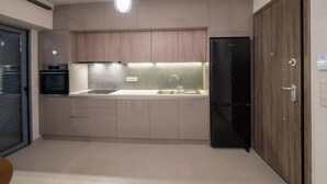 A modern kitchen with a built-in oven, a refrigerator, and a sink.