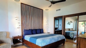 A bedroom with a wooden bed, a nightstand, a wicker chair, a ceiling fan, and a sliding glass door leading to another room.