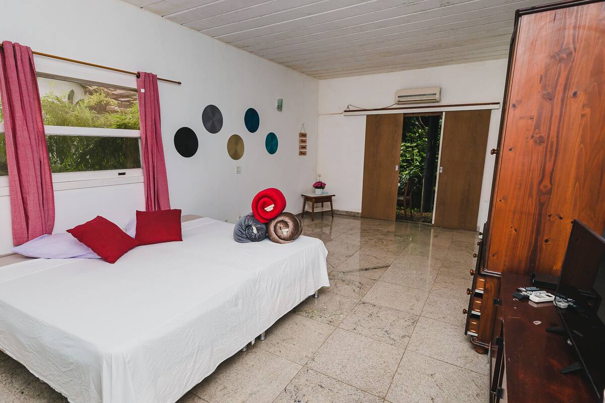 A bedroom with a bed, a wooden wardrobe, a window with curtains, and a wall with circular decorations.