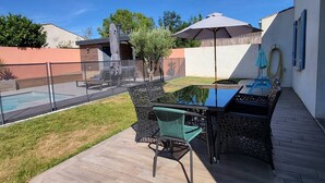 A backyard with a pool, outdoor furniture, and a patio area. - Villa proche de La Rochelle avec piscine (VILLEDOUX)