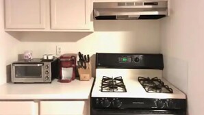 A kitchen with a gas stove, a microwave, and a coffee maker. - SPIFFY PRIVATE APT. WILLIAMSBURG PRIME BROOKLYN (Brooklyn)