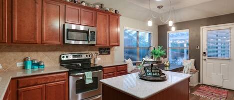 A kitchen with wooden cabinets, stainless steel appliances, and a central island.