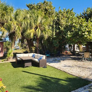 A patio area with a sofa, chairs, and a table.