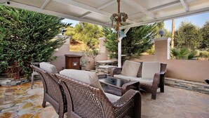 An outdoor patio with wicker furniture, a stone floor, and a pergola. - Studio Apartment 'Villa Dionysia 11' with Shared Pool, Wi-Fi and Air Conditioning (Zakynthos)