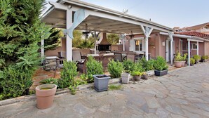 A covered outdoor patio with stone flooring, potted plants, and outdoor furniture. - Studio Apartment 'Villa Dionysia 11' with Shared Pool, Wi-Fi and Air Conditioning (Zakynthos)