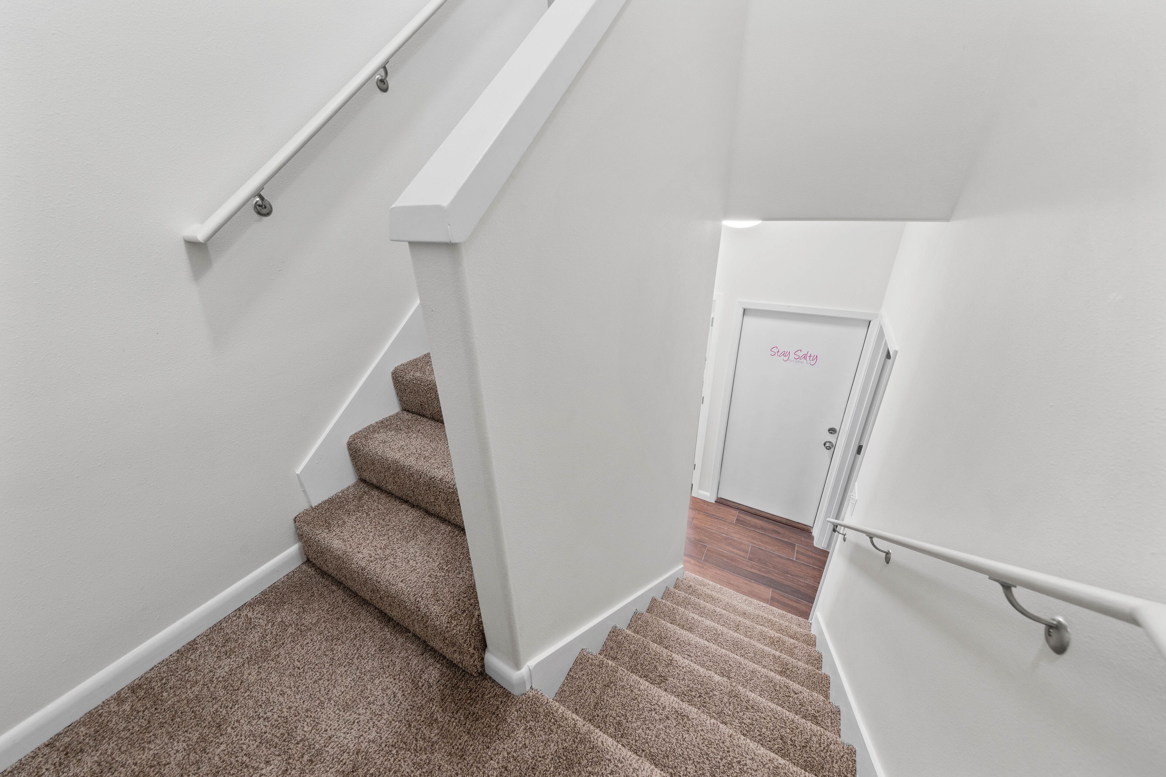 Un escalier avec des marches recouvertes de moquette et des murs blancs.