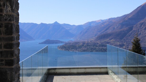 Un balcón con vista despejada a un lago y montañas.
