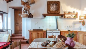 Eine Küche mit Holzausstattung, einem Esstisch mit Speisen und einem Bett mit roter Matratze.