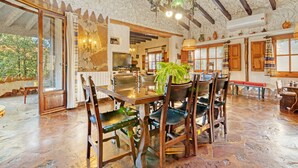 Un coin repas rustique, avec des meubles en bois, un lustre et un plafond en pierre.