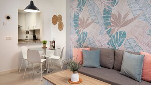 Ein modernes Wohnzimmer mit einer Couch, einem Couchtisch und einem Essbereich mit Stühlen.