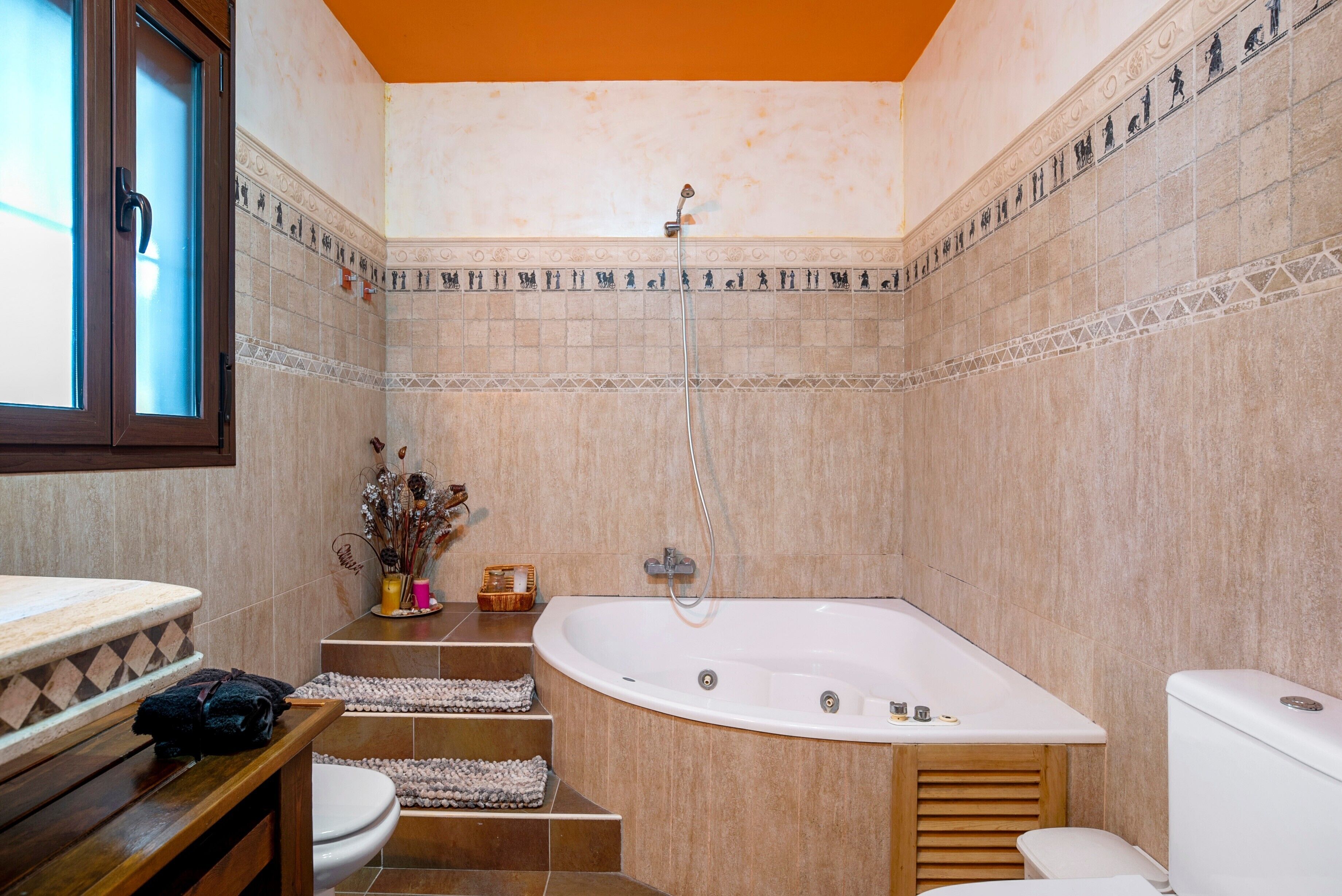 Een badkamer met een bad, toilet en douche.