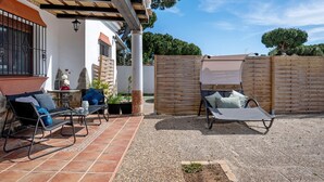 A patio area with outdoor furniture, a pergola, and a wooden fence. - Holiday Home "Villa Mami - families only" with Private Mini Pool, 2 Private Terraces and Wi-Fi (Chiclana de la frontera)