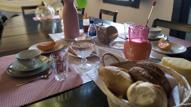 A dining table with various food items, including bread, cheese, and a pitcher.