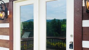 Una puerta blanca con un panel de vidrio, una terraza de madera y un felpudo.