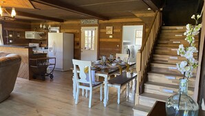 Un interior de madera con comedor, cocina y escalera.