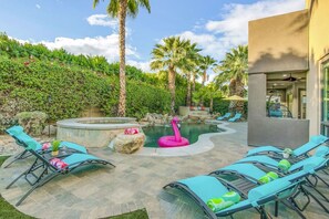 A pool area with lounge chairs, a hot tub, and a flamingo float. - Flamingo Palms: Pool, Spa, Pet-Friendly, Games! (Indio)