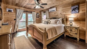 Ein Schlafzimmer einer Holzhütte mit Bett, Nachttisch und Deckenventilator.