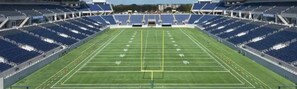 A large stadium with multiple tiers of seating and a central field.