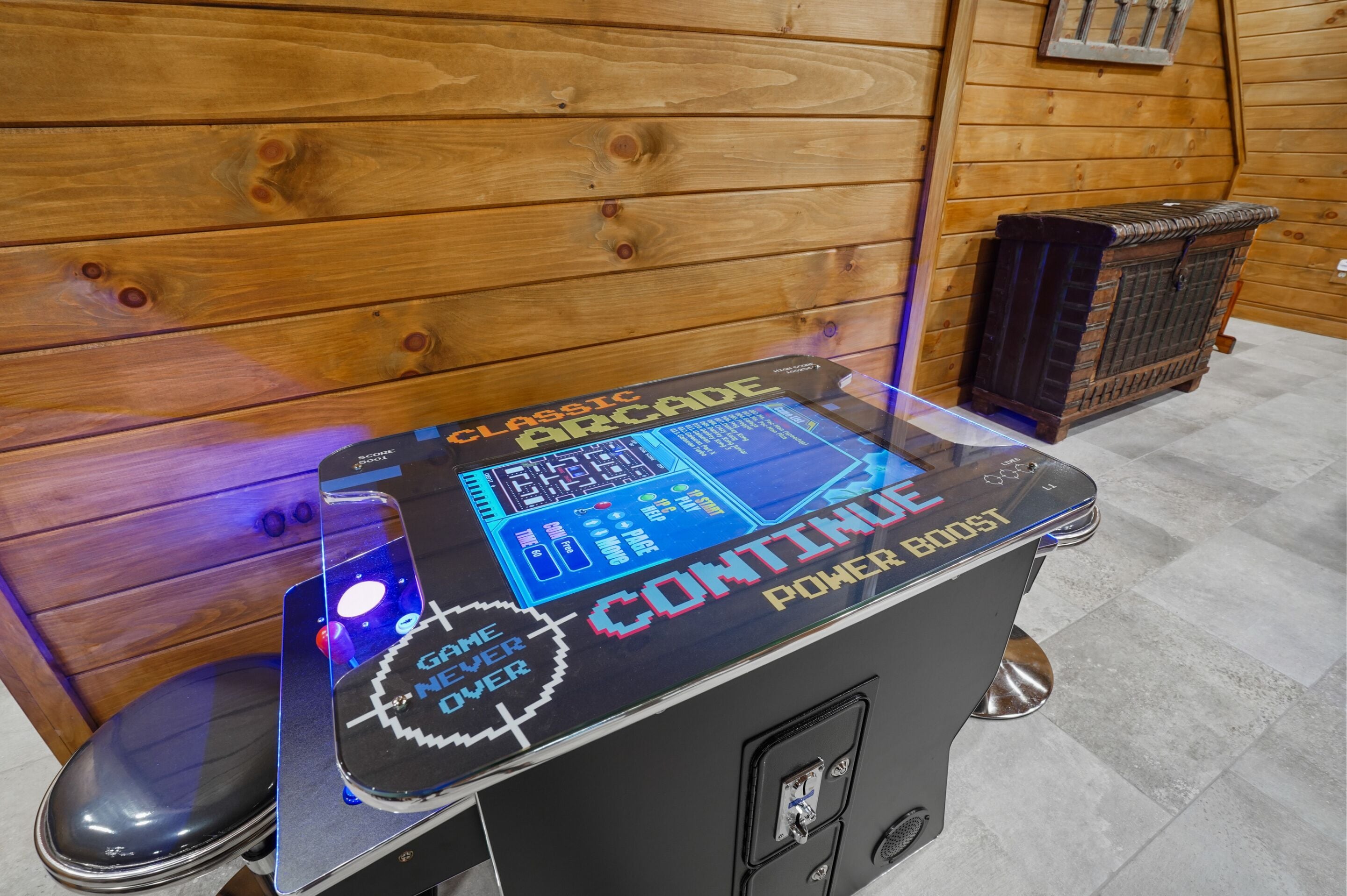 Una macchina arcade classica con piano in vetro e un cartello che indica la modalità potenziamento.