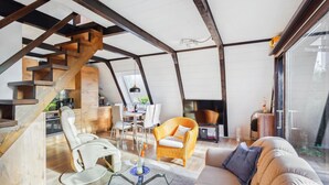 A modern interior with a loft-style design, featuring a dining area, seating, and a staircase. - Cozy home in Bad Wünnenberg with WiFi (Bad Wünnenberg)