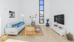 A modern living room with a sofa, chairs, a TV, and a window with a view.
