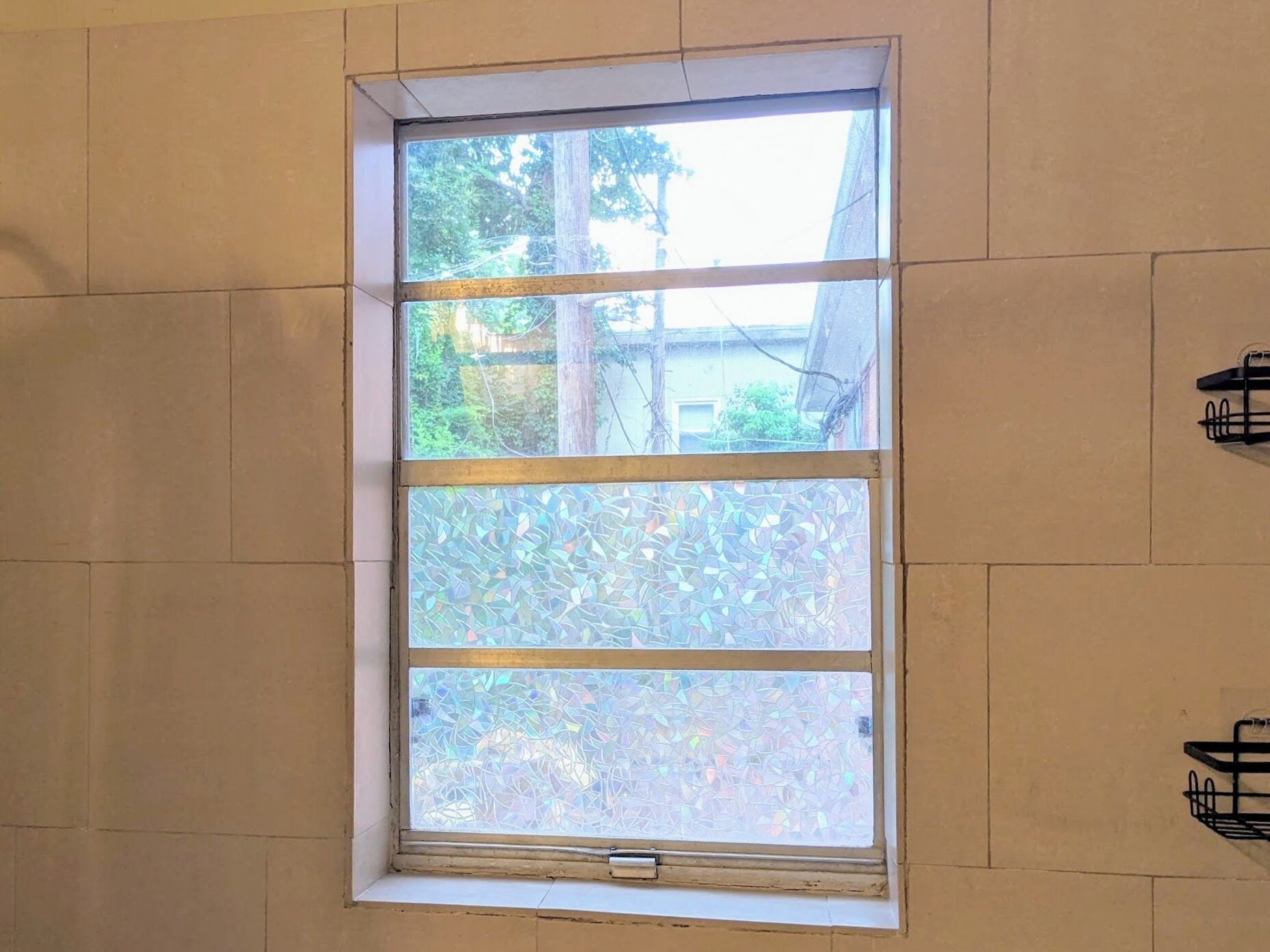 A window with a view of trees and a building outside.