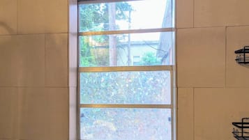 A window with a view of trees and a building outside.