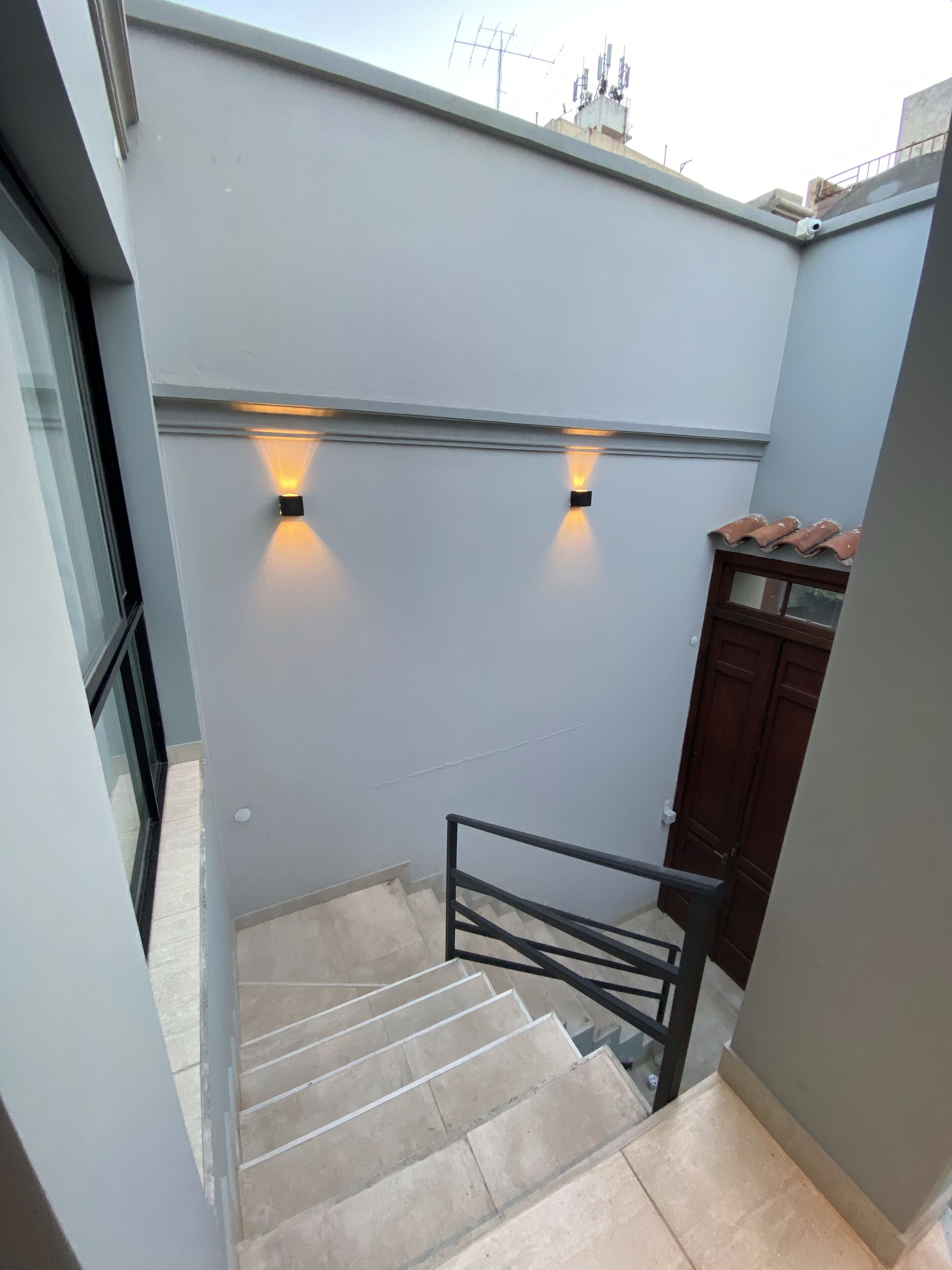 Un escalier avec une rampe métallique menant à un palier.