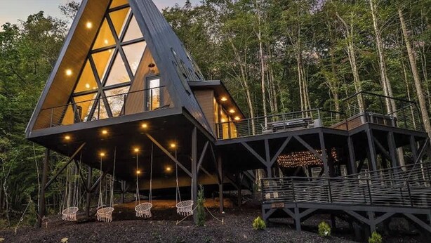 A modern, triangular wooden cabin with a large glass window, surrounded by a forest. - Sky-High A Frame Retreat Hottub & EV charging (Beech Mountain)