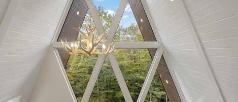 Un interior moderno con una estructura de techo triangular y una araña.